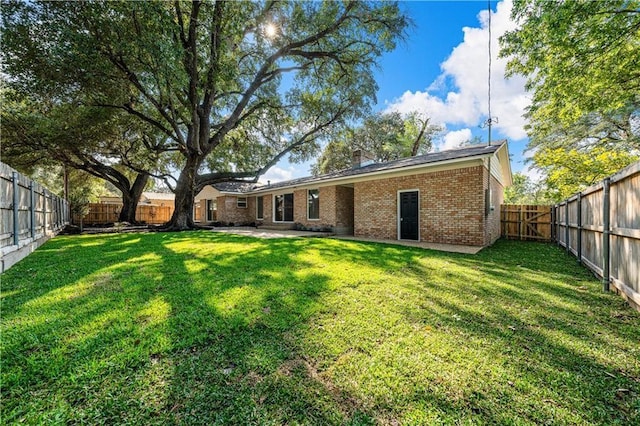 rear view of property with a patio area and a yard