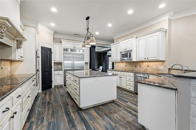 kitchen featuring sink, dark hardwood / wood-style floors, built in appliances, pendant lighting, and a kitchen island