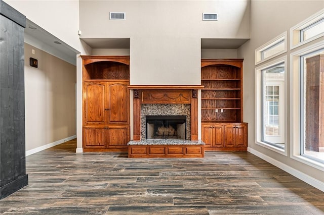 unfurnished living room with a fireplace, dark hardwood / wood-style floors, and high vaulted ceiling