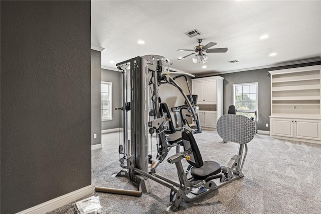 exercise room featuring ceiling fan and ornamental molding