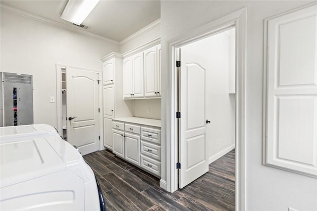 washroom featuring dark hardwood / wood-style floors, cabinets, crown molding, and washing machine and clothes dryer