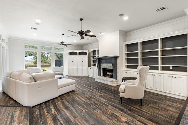 living room featuring dark hardwood / wood-style flooring, ornamental molding, and a brick fireplace