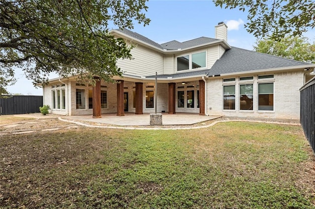 rear view of property with a lawn and a patio