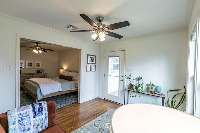 bedroom featuring access to exterior, visible vents, crown molding, and wood finished floors