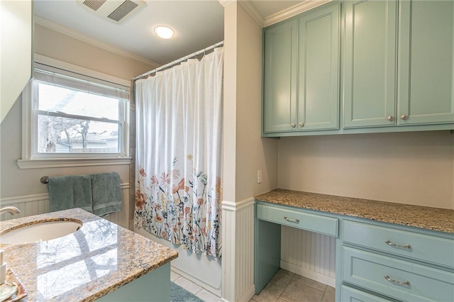 full bathroom featuring visible vents, wainscoting, tile patterned floors, crown molding, and vanity