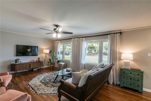 living area featuring baseboards, ceiling fan, ornamental molding, and wood finished floors