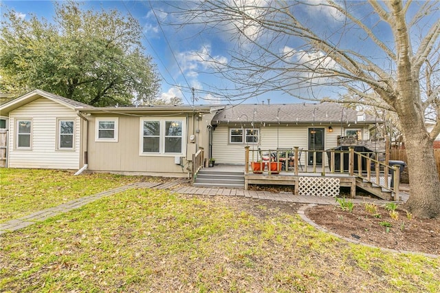 back of house with a lawn and a wooden deck