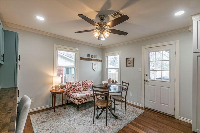 dining area featuring a healthy amount of sunlight, baseboards, dark wood-style flooring, and crown molding