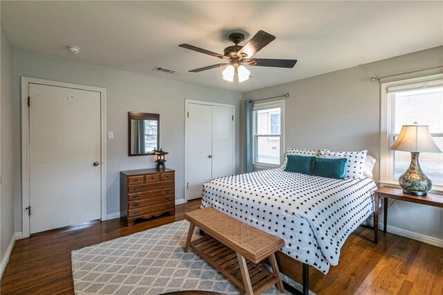 bedroom featuring multiple windows, wood finished floors, and baseboards