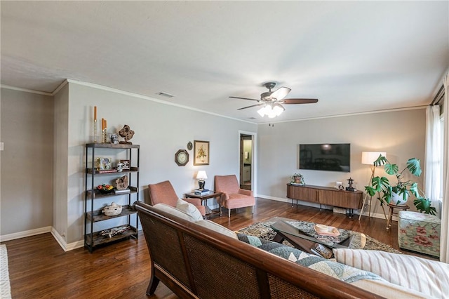 living area with crown molding, dark wood finished floors, a ceiling fan, and baseboards