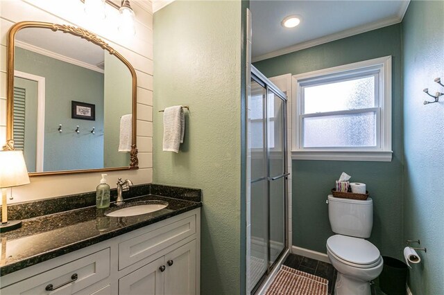 bathroom with toilet, a shower stall, ornamental molding, and vanity