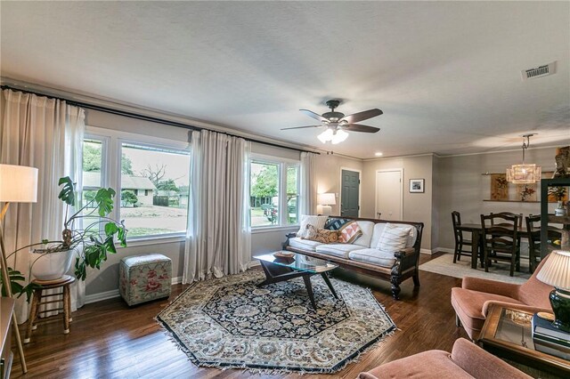 living room featuring dark wood-style flooring, visible vents, ceiling fan, and baseboards