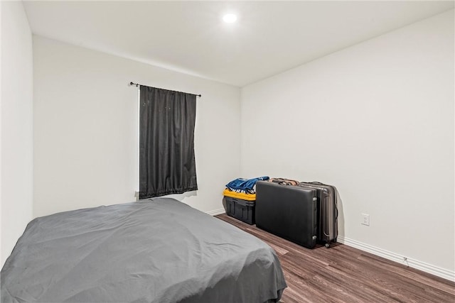 bedroom featuring dark wood finished floors and baseboards