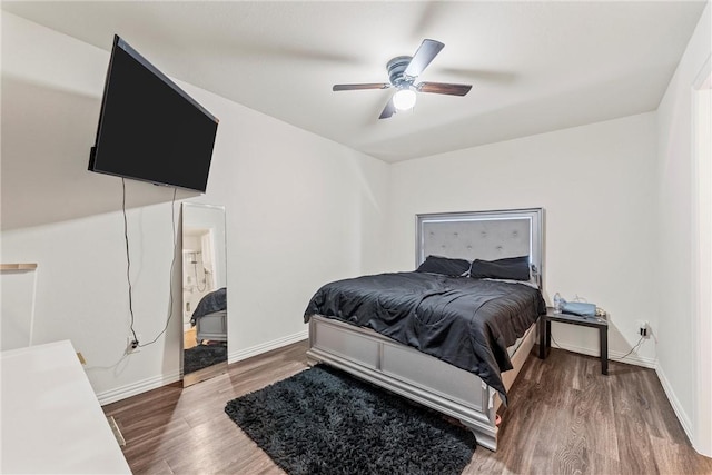 bedroom featuring ceiling fan, baseboards, and wood finished floors