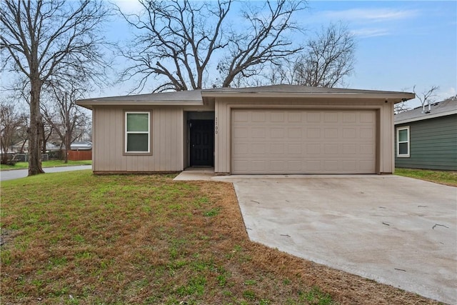 view of front of house featuring an attached garage, driveway, and a front lawn