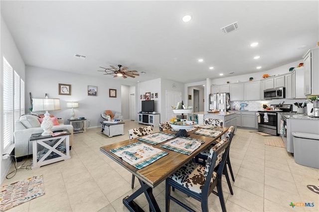 tiled dining space with ceiling fan