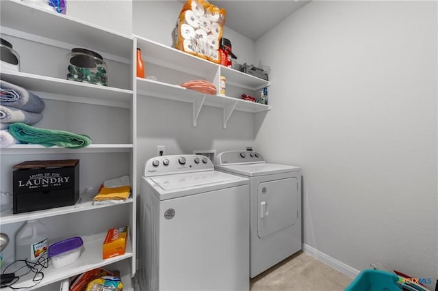 laundry room featuring washer and clothes dryer and light colored carpet