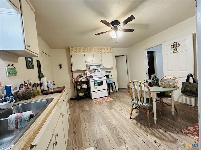 kitchen featuring white range with electric stovetop, sink, white cabinets, ceiling fan, and light hardwood / wood-style floors