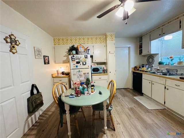 kitchen featuring dishwasher, sink, white fridge, ceiling fan, and light wood-type flooring