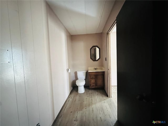 bathroom featuring wood-type flooring, toilet, and vanity