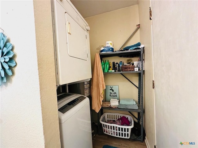 clothes washing area with stacked washer / dryer