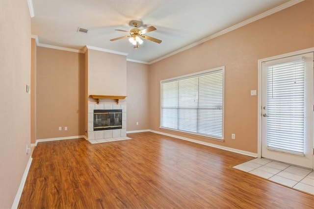 unfurnished living room with a tile fireplace, light hardwood / wood-style flooring, ceiling fan, and ornamental molding