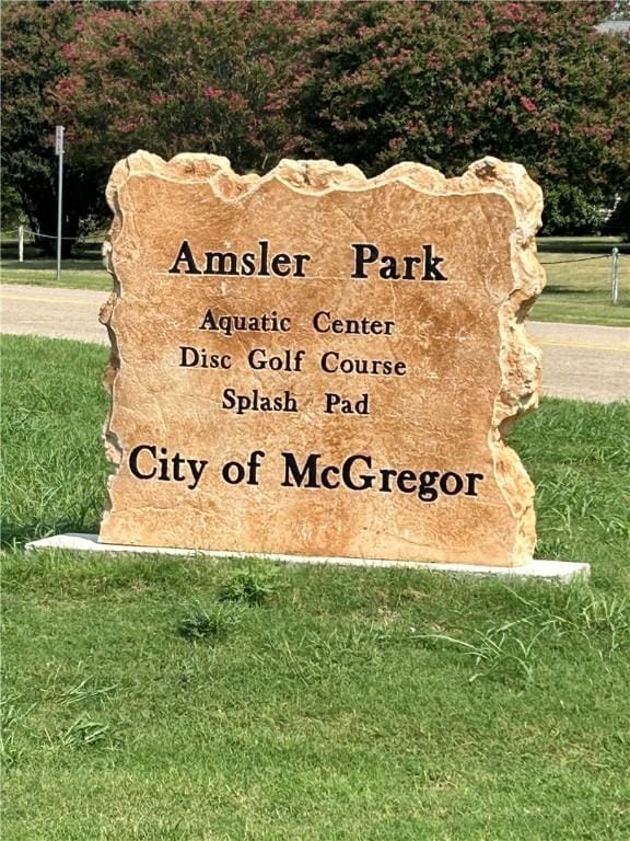 community / neighborhood sign featuring a lawn