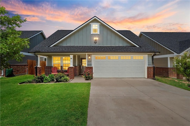 craftsman-style house featuring a garage, covered porch, and a lawn