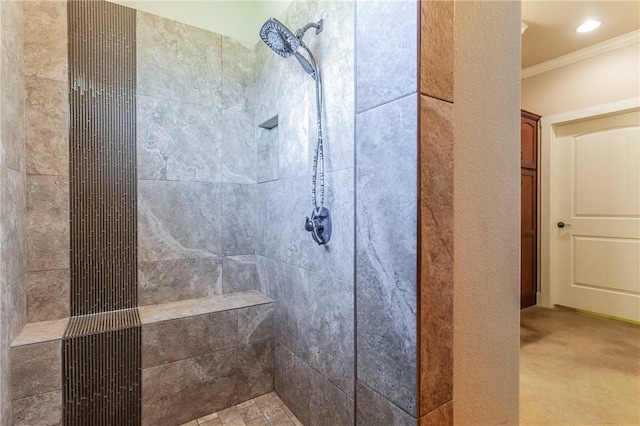 bathroom with crown molding and tiled shower