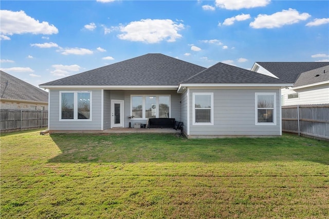 back of house with a yard, a fenced backyard, and a patio area