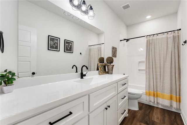 full bath featuring visible vents, toilet, wood finished floors, shower / bath combination with curtain, and vanity