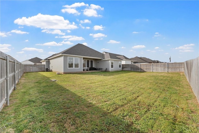 back of property with a lawn and a fenced backyard