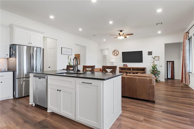 kitchen featuring dark countertops, visible vents, appliances with stainless steel finishes, a ceiling fan, and a sink