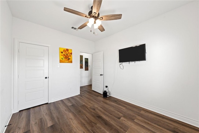 unfurnished bedroom with visible vents, baseboards, dark wood finished floors, and a ceiling fan