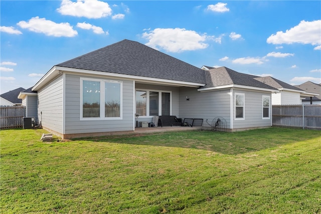 rear view of property with cooling unit, a yard, roof with shingles, and fence