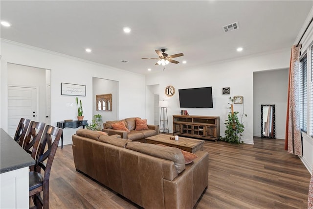 living room with dark wood-type flooring, crown molding, recessed lighting, and a ceiling fan