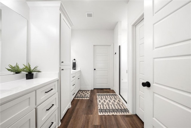 full bath with visible vents, a stall shower, vanity, and wood finished floors