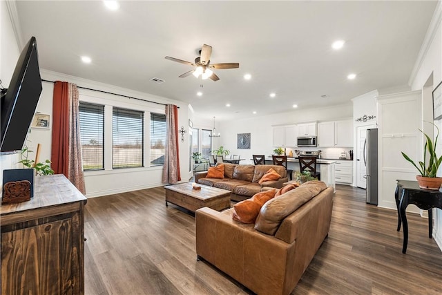 living room featuring a ceiling fan, visible vents, recessed lighting, dark wood-type flooring, and crown molding