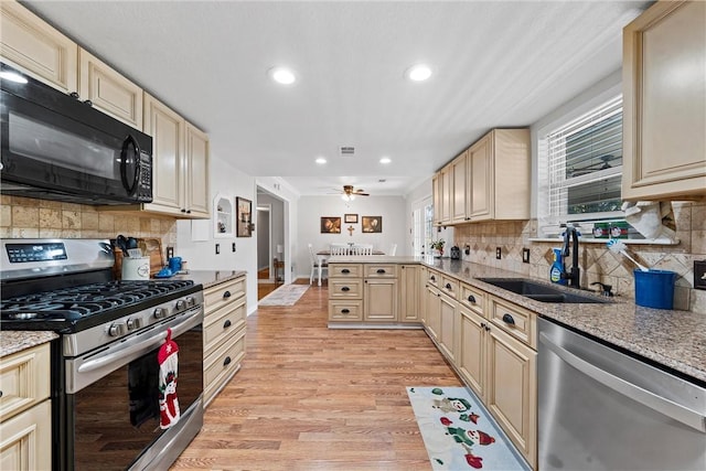 kitchen with sink, tasteful backsplash, light hardwood / wood-style floors, kitchen peninsula, and stainless steel appliances