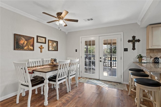 dining space featuring french doors, dark hardwood / wood-style floors, and crown molding