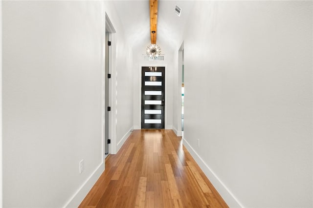 doorway with beamed ceiling and wood-type flooring