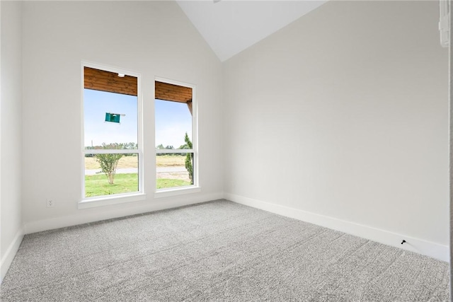 carpeted empty room with high vaulted ceiling