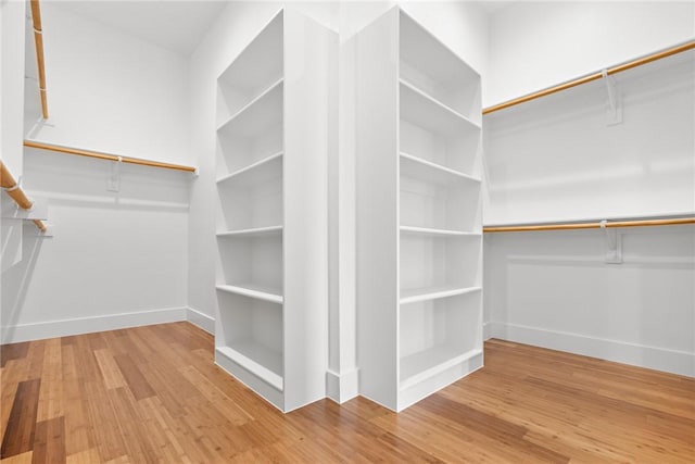 walk in closet with light hardwood / wood-style floors