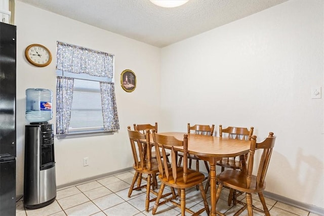 dining space with light tile patterned floors and a textured ceiling