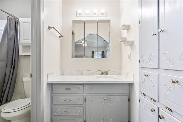 full bathroom with ceiling fan, vanity, shower / bath combo, and toilet