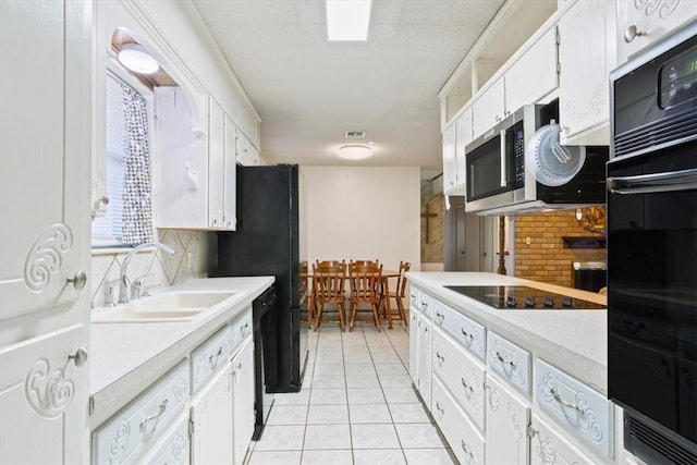 kitchen featuring black appliances, decorative backsplash, white cabinetry, and sink