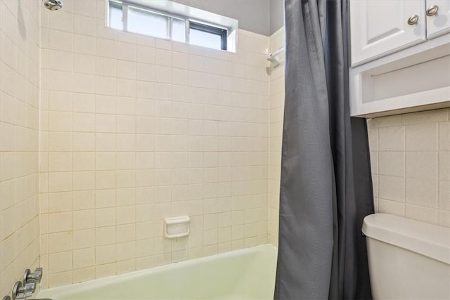 bathroom with shower / bathtub combination with curtain and toilet