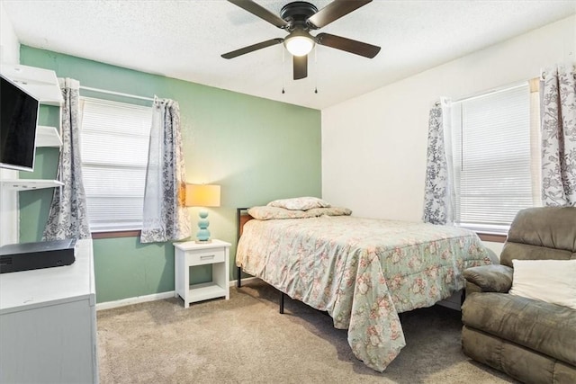 carpeted bedroom featuring multiple windows, a textured ceiling, and ceiling fan