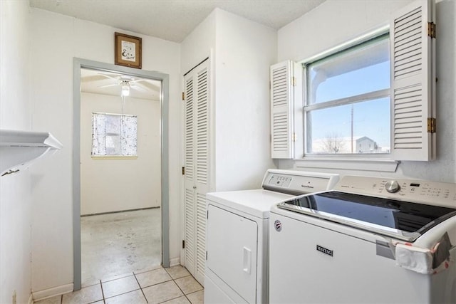 laundry area with separate washer and dryer and light tile patterned floors