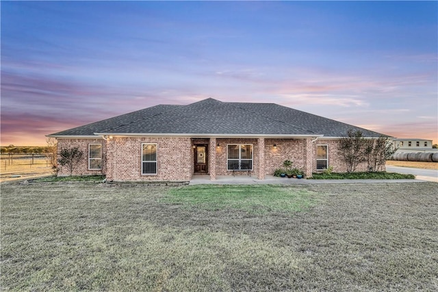 view of front of home with a patio and a lawn